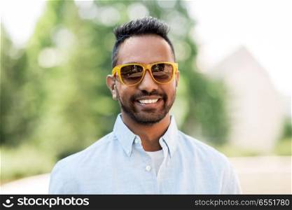 people, summer and eyewear concept - happy young indian man in sunglasses. happy young indian man in sunglasses outdoors. happy young indian man in sunglasses outdoors
