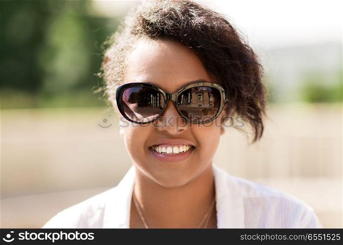 people, summer and eyewear - happy african american young woman in sunglasses outdoors. happy african american young woman in sunglasses. happy african american young woman in sunglasses