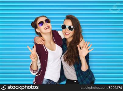 people, summer and fashion concept - happy smiling pretty teenage girls or friends in sunglasses showing peace hand sign over blue ribbed background. smiling teenage girls in sunglasses showing peace