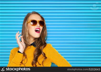people, summer and fashion concept - happy young woman or teen girl in casual clothes and sunglasses over blue ribbed background. happy young woman or teen girl in casual clothes