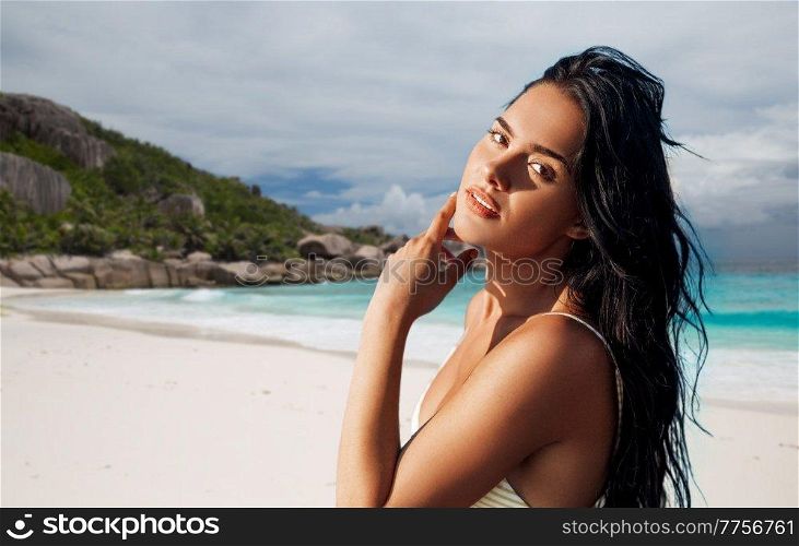people, summer and swimwear concept - beautiful young woman in bikini swimsuit over tropical beach background in french polynesia. beautiful young woman in bikini swimsuit on beach