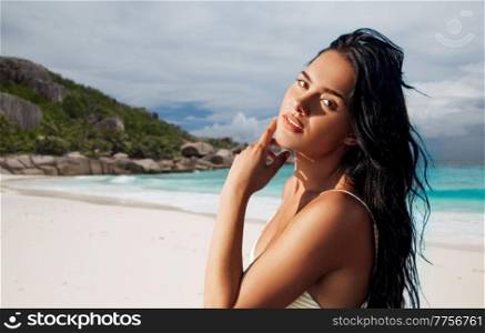 people, summer and swimwear concept - beautiful young woman in bikini swimsuit over tropical beach background in french polynesia. beautiful young woman in bikini swimsuit on beach