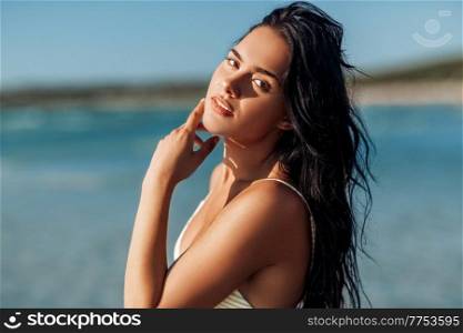 people, summer and swimwear concept - beautiful young woman in bikini swimsuit on beach. beautiful young woman in bikini swimsuit on beach
