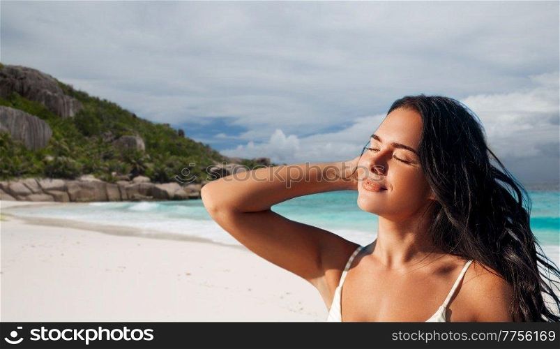 people, summer and swimwear concept - happy beautiful young woman in bikini swimsuit over tropical beach background in french polynesia. beautiful young woman in bikini swimsuit on beach