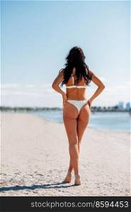 people, summer and swimwear concept - young woman in bikini swimsuit on beach. young woman in bikini swimsuit on beach