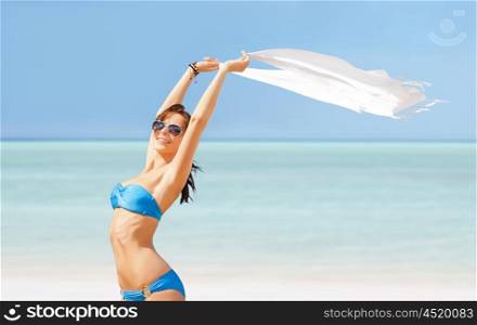 people, summer holidays and vacation concept - happy beautiful woman in bikini and sunglasses with pareo on exotic maldives beach
