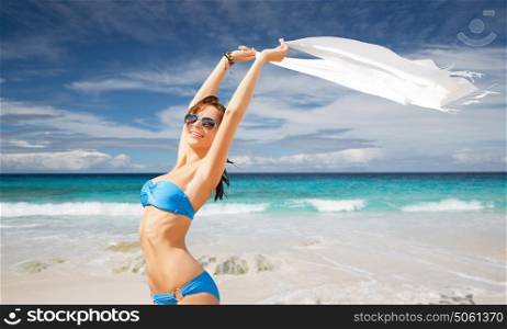 people, summer holidays, travel and vacation concept - beautiful woman in bikini and sunglasses with pareo over exotic tropical beach and ocean background. woman in bikini and sunglasses with pareo on beach