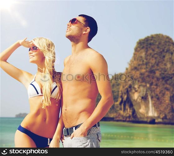 people, summer holidays, travel and vacation concept - happy couple over exotic tropical beach background