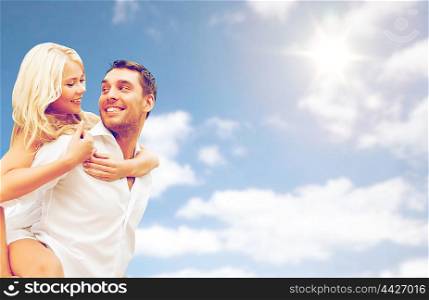people, summer holidays, vacation and love concept - happy couple having fun over blue sky and clouds background