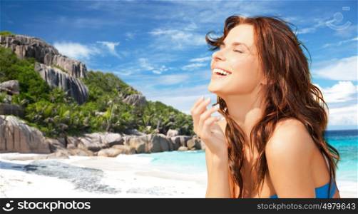 people, summer holidays, vacation and travel concept - happy smiling young woman enjoying sun over exotic tropical beach and sea shore background. happy smiling young woman on tropical beach