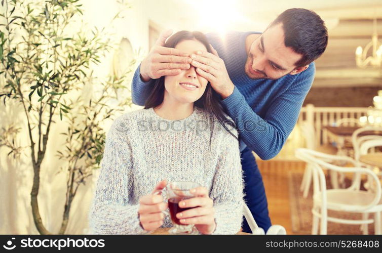 people, surprise and dating concept - happy couple drinking tea at cafe or restaurant. happy couple drinking tea at cafe