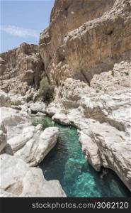 People swimming in the clear turquoise water of Wadi Bani Khalid, Sultanate of Oman, Middle East. People swiming in the pools of Wadi Bani Khalid, Oman
