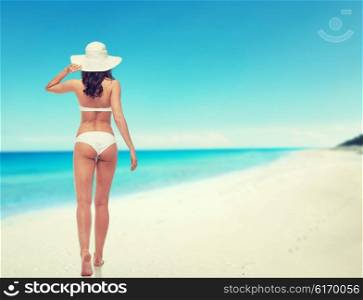 people, swimwear, beauty, travel and summer concept - young woman in white bikini swimsuit from back over beach background
