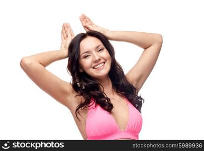 people, swimwear, summer beach and sexual concept - happy young woman in pink bikini swimsuit making bunny ears gesture