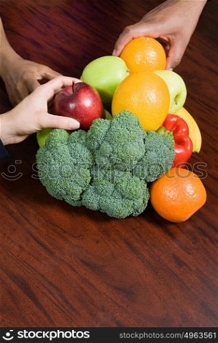People taking fruit from table