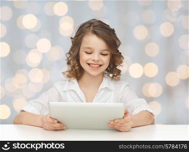 people, technology and children concept - happy smiling girl with tablet pc computer over holidays lights background