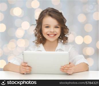 people, technology and children concept - happy smiling girl with tablet pc computer over holidays lights background