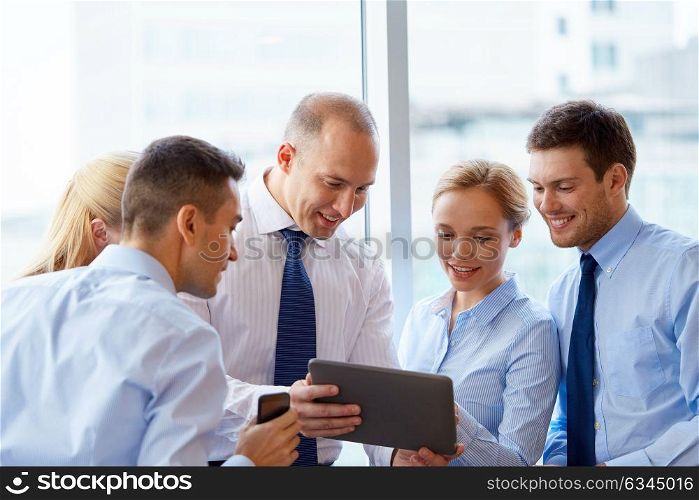 people, technology and corporate concept - business team with tablet pc computer at office. business people with tablet pc computer at office