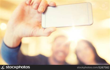 people, technology and dating concept - close up of happy couple taking smartphone selfie at cafe or restaurant. close up of couple taking smartphone selfie