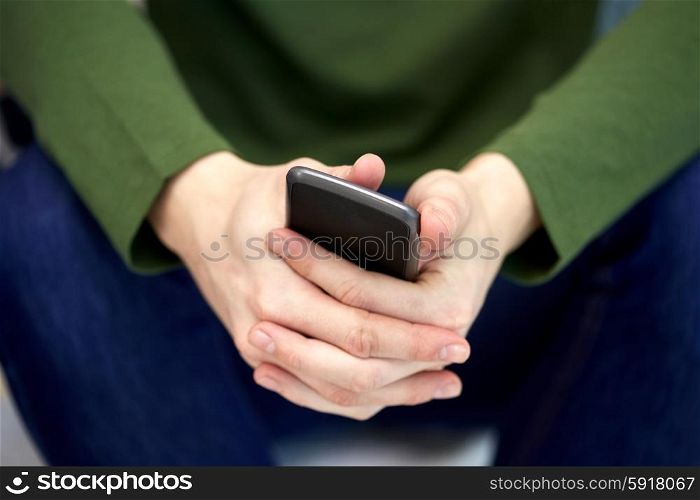 people, technology and internet concept - close up of male hands with smartphone at school