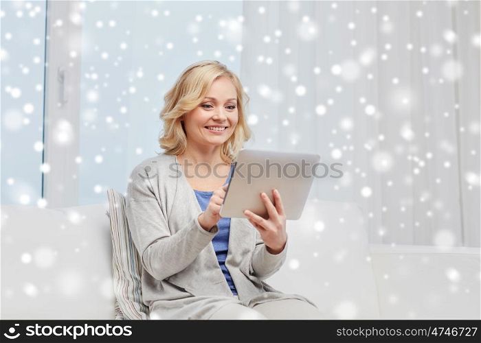 people, technology and internet concept - happy middle aged woman with tablet pc computer at home over snow