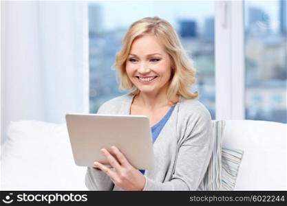 people, technology and internet concept - happy middle aged woman with tablet pc computer at home