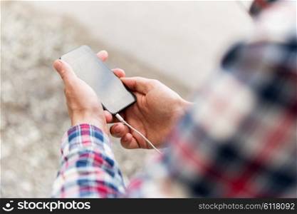 people, technology and leisure - close up of young man with smartphone on street