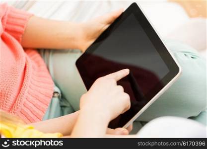 people, technology and leisure concept - close up of young women with tablet pc computer at home