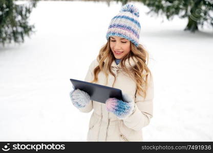 people, technology and leisure concept - happy smiling woman with tablet computer outdoors in winter. woman with tablet computer outdoors in winter