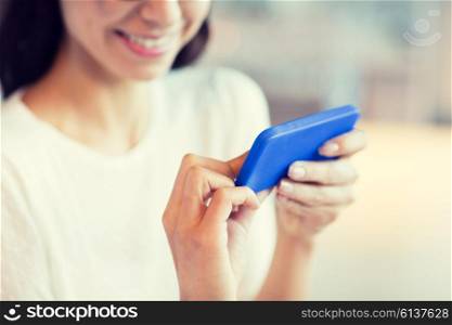 people, technology and lifestyle concept - close up of woman with smartphone at cafe