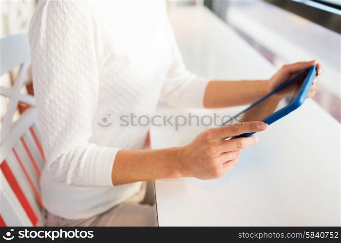 people, technology and lifestyle concept - close up of woman with tablet pc computer at cafe