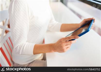 people, technology and lifestyle concept - close up of woman with tablet pc computer at cafe