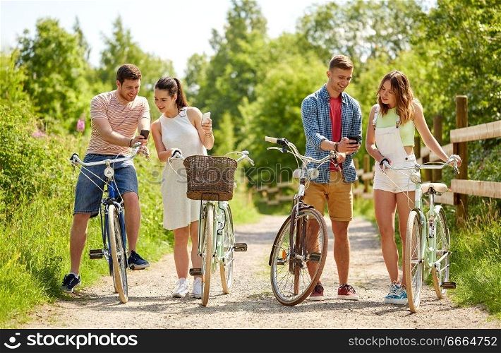 people, technology and lifestyle concept - happy couple with bicycles and smartphone at country in summer. couple with bicycles and smartphone in summer