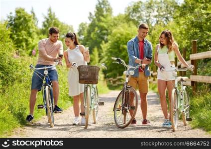 people, technology and lifestyle concept - happy couple with bicycles and smartphone at country in summer. couple with bicycles and smartphone in summer