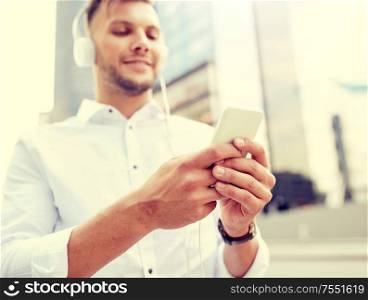 people, technology and lifestyle - man with smartphone and headphones listening music. man with smartphone and headphones listening music