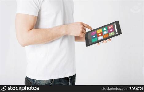 people, technology and media concept - close up of man with application icons on tablet pc computer