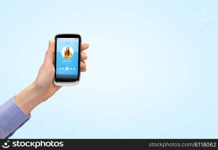 people, technology and media concept - close up of woman hand with smartphone and with music player