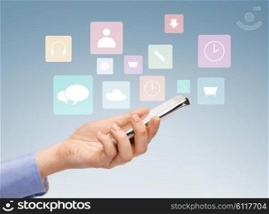 people, technology and media concept - close up of woman hand with smartphone and application icons