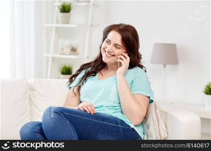 people, technology, communication and leisure concept - happy plus size young woman calling on smartphone at home