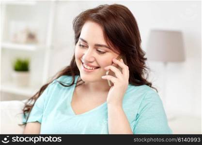 people, technology, communication and leisure concept - happy plus size young woman calling on smartphone at home