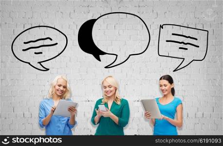 people, technology, communication and leisure concept - happy women with smartphone and tablet pc computers over gray brick wall background with text bubbles