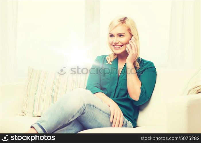 people, technology, communication and leisure concept - happy young woman calling on smartphone at home. happy young woman calling on smartphone at home