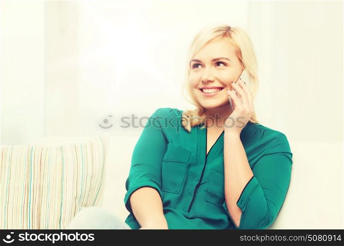 people, technology, communication and leisure concept - happy young woman calling on smartphone at home. happy young woman calling on smartphone at home