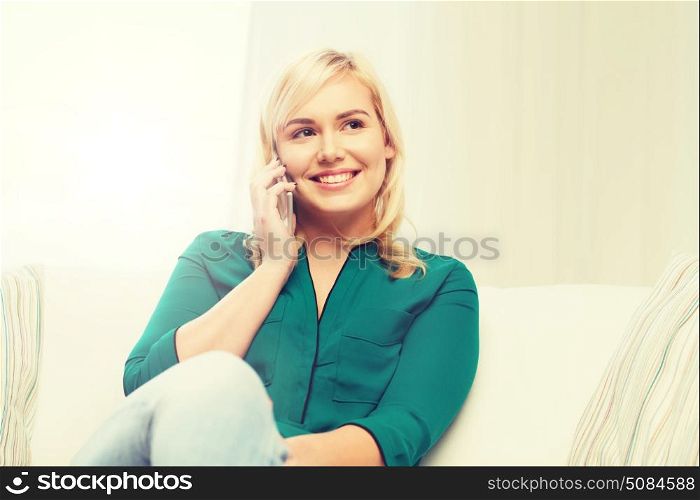 people, technology, communication and leisure concept - happy young woman calling on smartphone at home. happy young woman calling on smartphone at home. happy young woman calling on smartphone at home