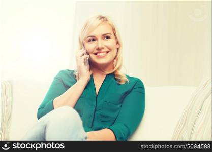 people, technology, communication and leisure concept - happy young woman calling on smartphone at home. happy young woman calling on smartphone at home. happy young woman calling on smartphone at home