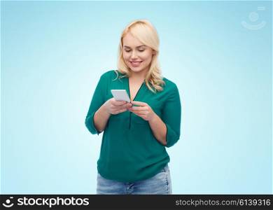people, technology, communication and leisure concept - happy young woman with smartphone texting message over blue background