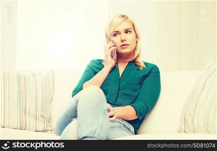 people, technology, communication and leisure concept - young woman calling on smartphone at home. young woman calling on smartphone at home