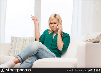 people, technology, communication and leisure concept - young woman calling on smartphone at home