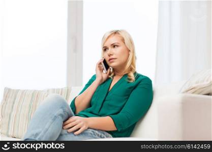people, technology, communication and leisure concept - young woman calling on smartphone at home