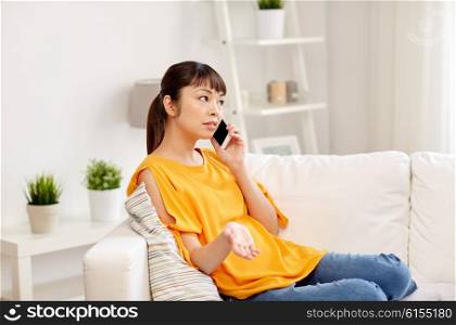 people, technology, communication and problem concept - young asian woman calling on smartphone at home